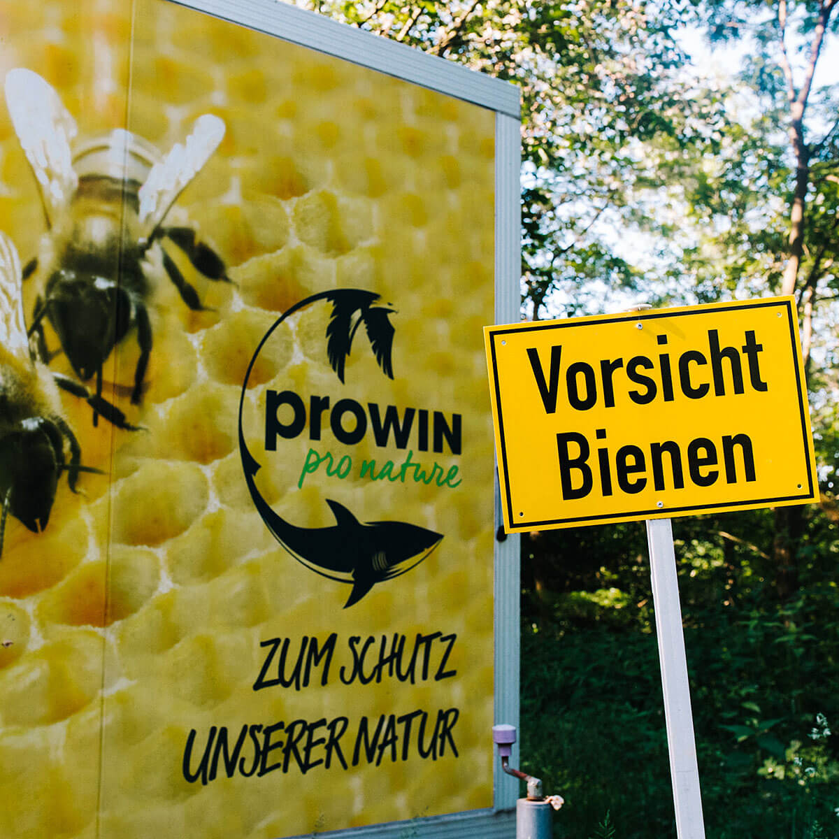 Panneau avec l'inscription "Attention aux abeilles" et ruche mobile pro nature